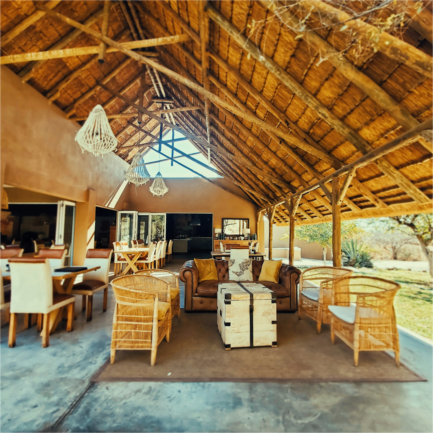 Open-air safari lodge lounge with a thatched roof